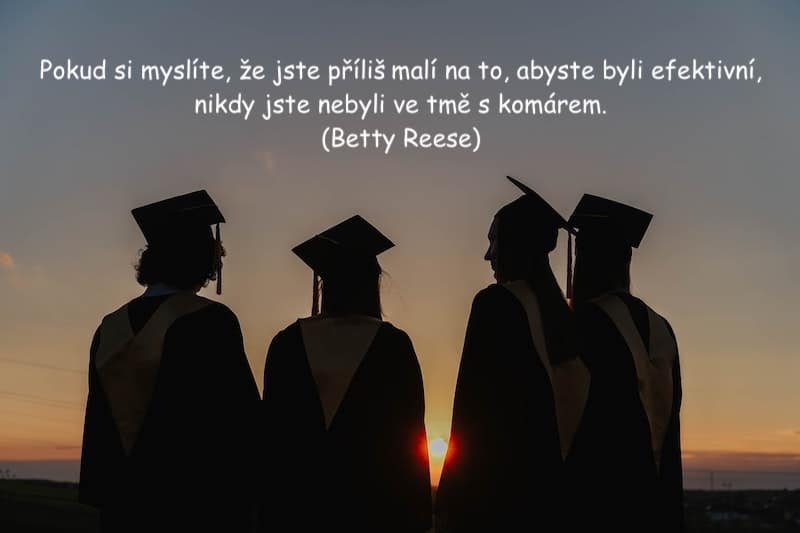 Čtyři studenti po ukončení studia v siluetách proti západu slunce.